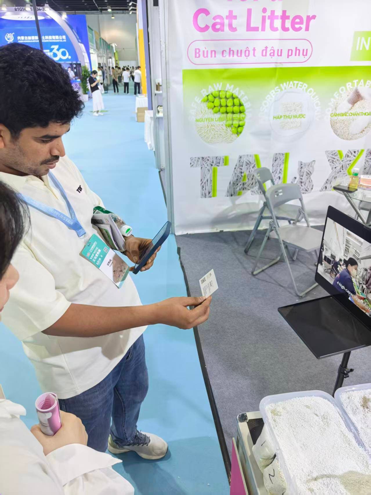 RootPurr trade-show interaction — buyer reviewing the Pea-Fiber Tofu Cat Litter range with a RootPurr representative.