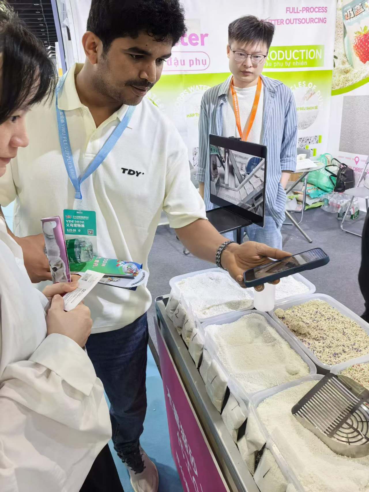 Distributors discussing the RootPurr plant-based litter line at the brand's exhibition booth.